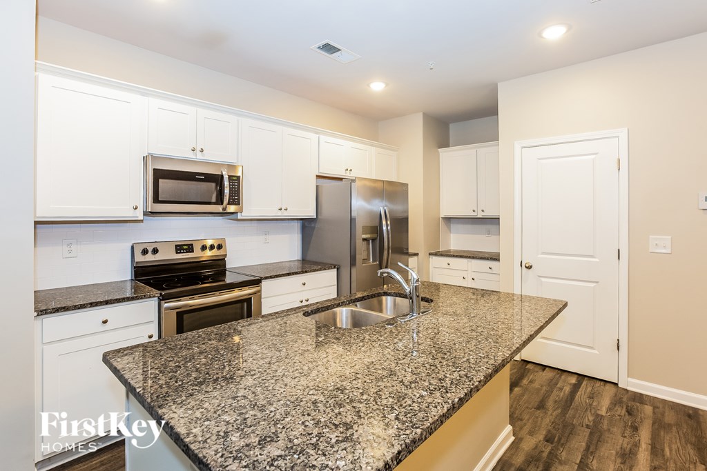 A kitchen with granite countertops and stainless steel appliances.