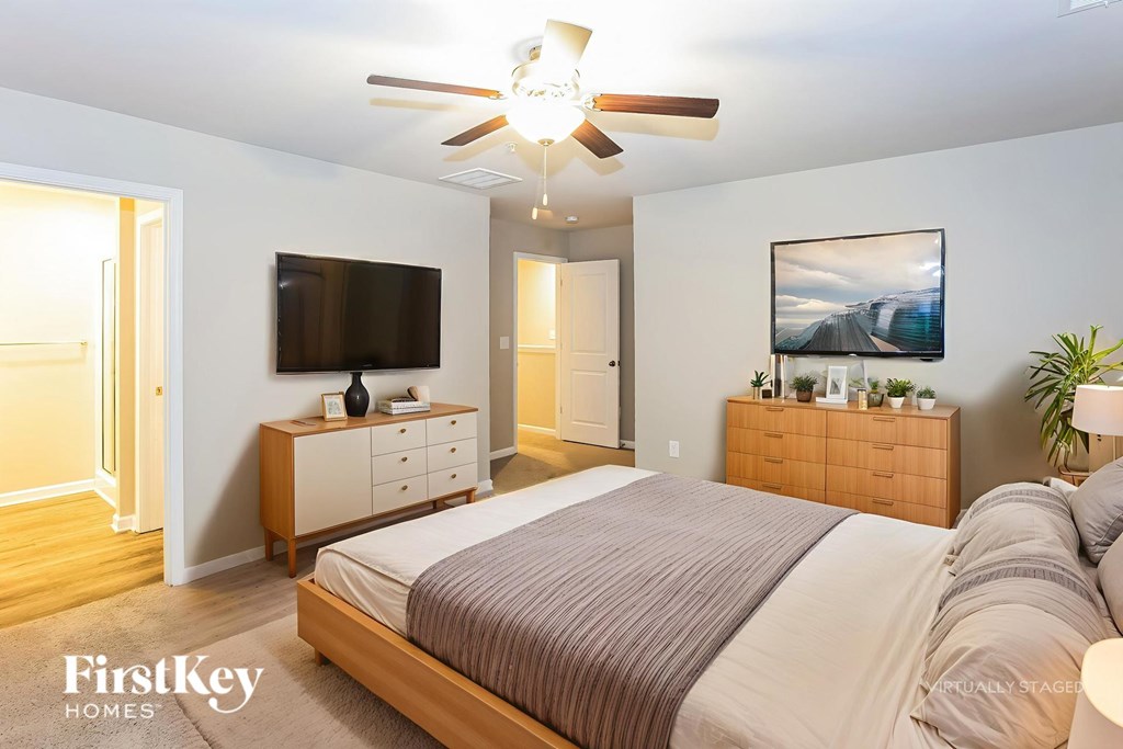 A bedroom with a bed, dresser, and tv.