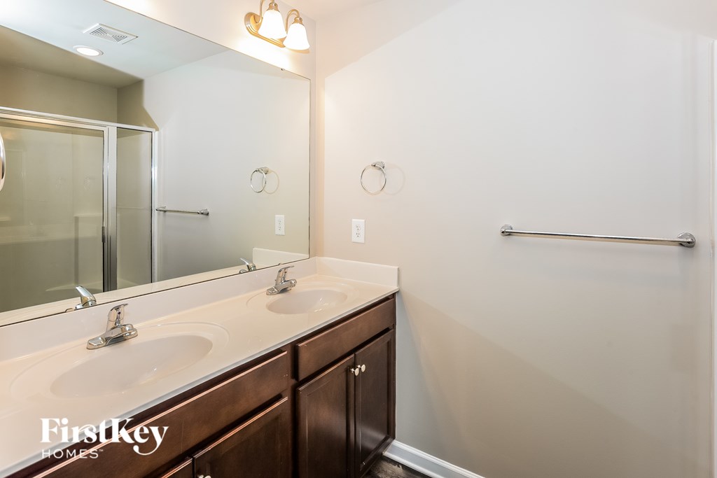 A bathroom with a double sink and a mirror.