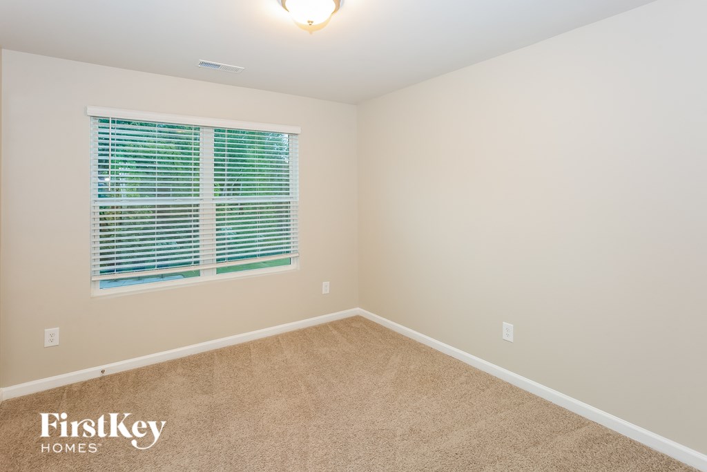 A room with a window covered by blue blinds.