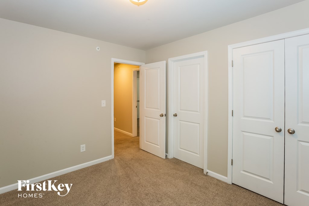 A room with white doors and a carpeted floor.