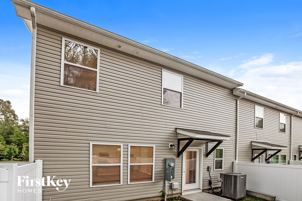 A modern house with a grey facade and a white fence.