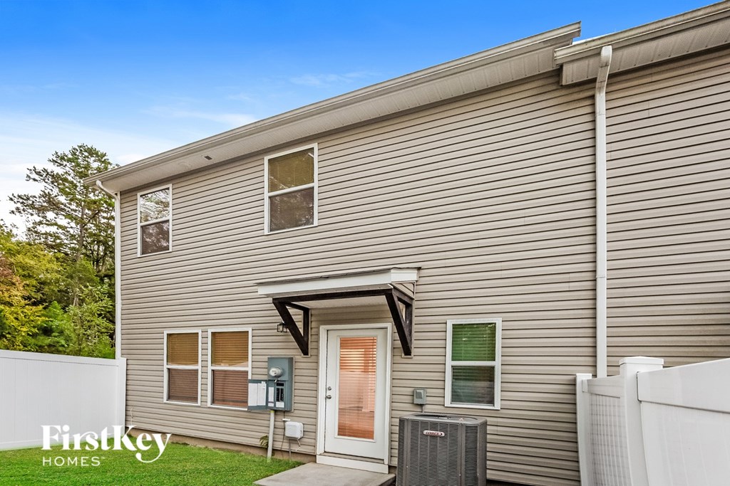 A house with a brown siding and a white fence.
