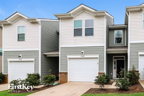 a white and gray house with two garage doors