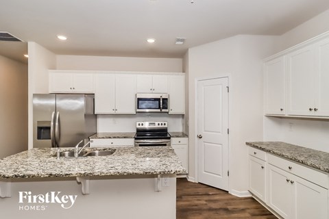 a kitchen with white cabinets and granite counter tops and a sink