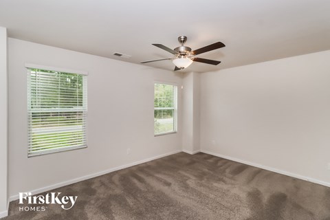 a living room with carpet and a ceiling fan