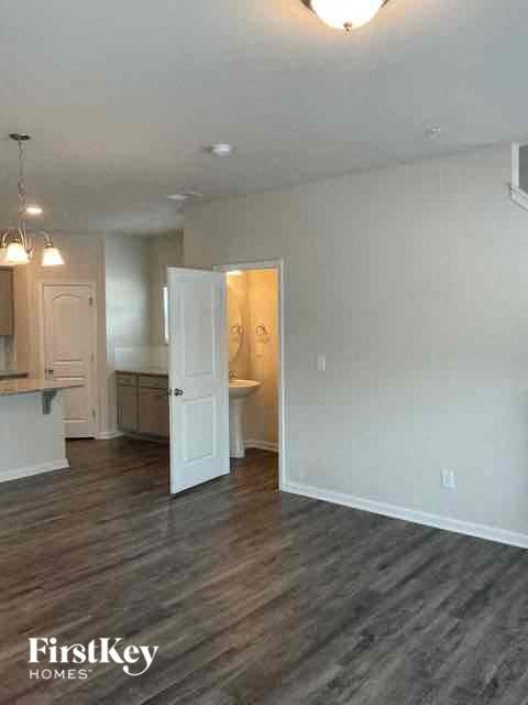 an empty living room with a door to a bathroom