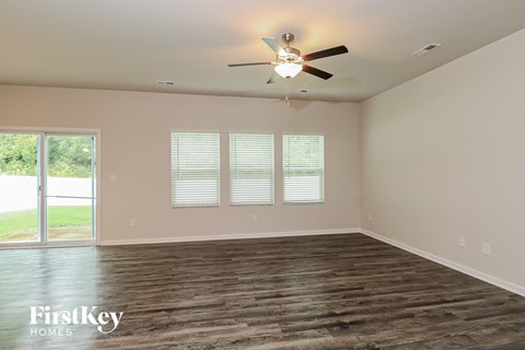 A room with a ceiling fan and wooden flooring.