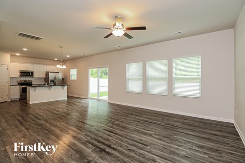 A spacious room with a ceiling fan and wooden flooring.