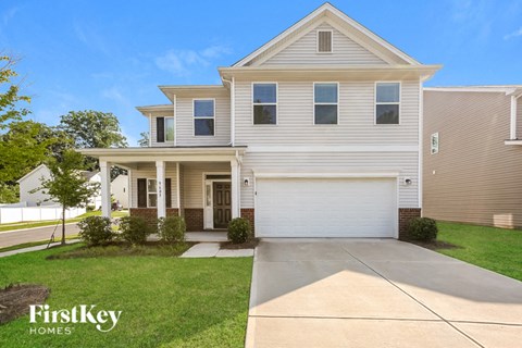 a white house with a driveway in front of it