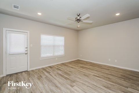 A room with a ceiling fan and wooden flooring.
