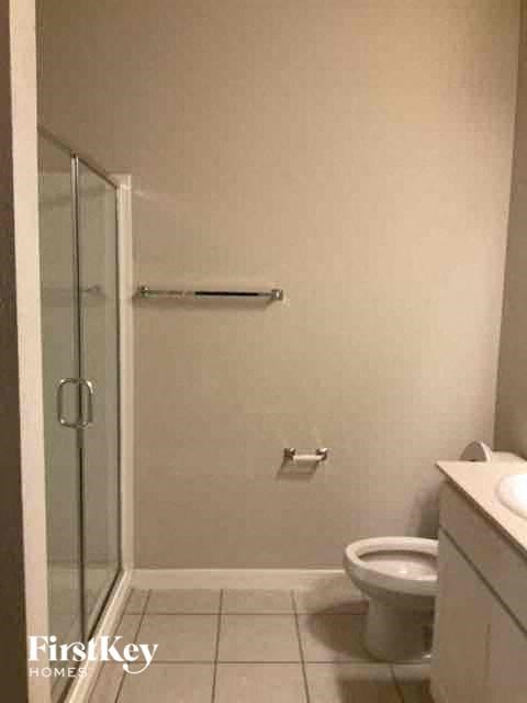 a white bathroom with a toilet and a shower