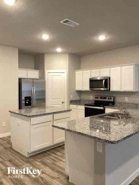 a kitchen with marble counter tops and white cabinets