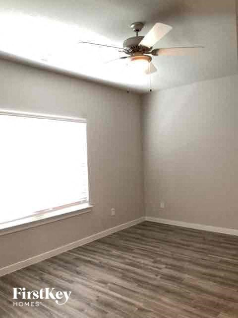a empty room with a ceiling fan and a window
