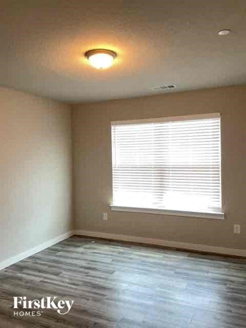 an empty room with a window and wood floors