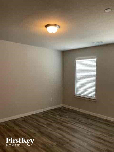 an empty room with a lamp on the ceiling and a window