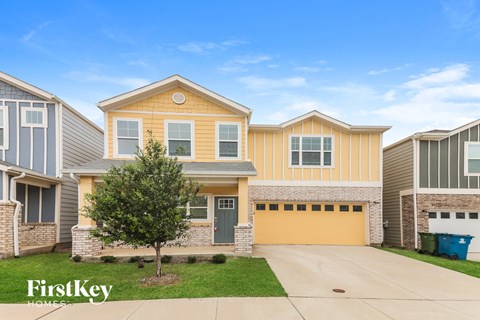 a yellow and brick house with a yellow garage door