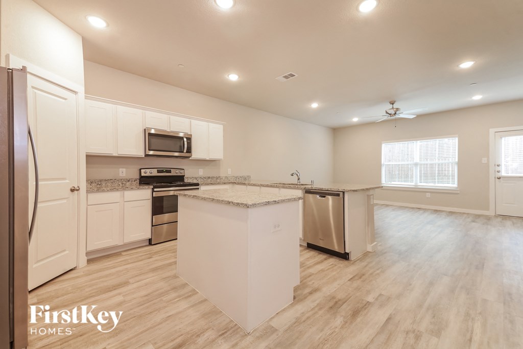 a large kitchen with white cabinets and stainless steel appliances
