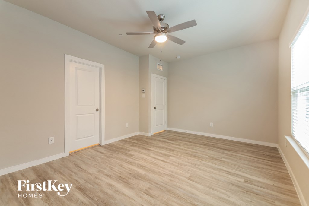a living room with a ceiling fan and a wood floor