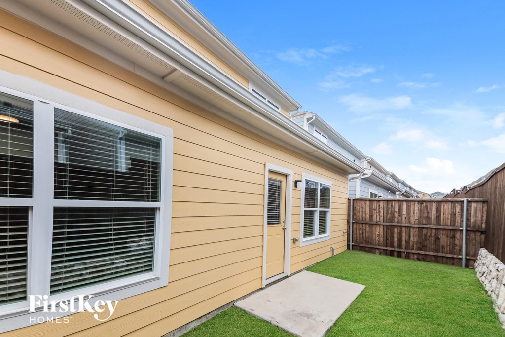 the backyard of a house with a yard and a fence