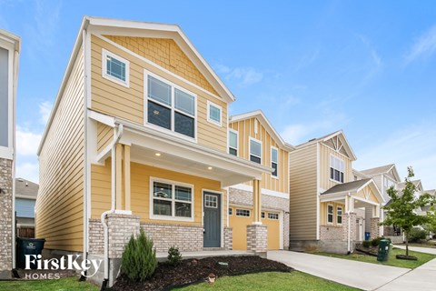 a row of homes with yellow siding and a sidewalk