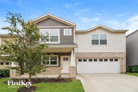 a home with a white garage door and a brick house
