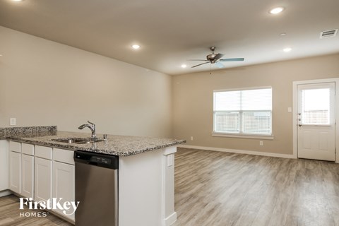 a kitchen with a counter top and a sink and a ceiling fan