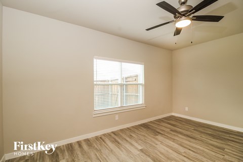 a bedroom with a ceiling fan and a window