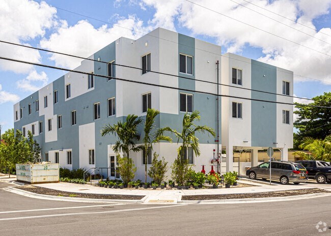 a white and blue building with cars parked in front of it