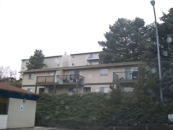a large apartment building with trees in front of it