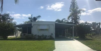 A white building with a green lawn in front.