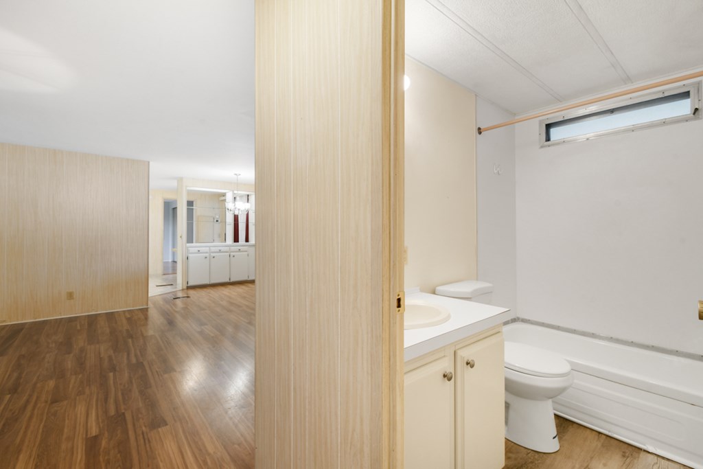 A bathroom with a toilet, sink and bathtub.