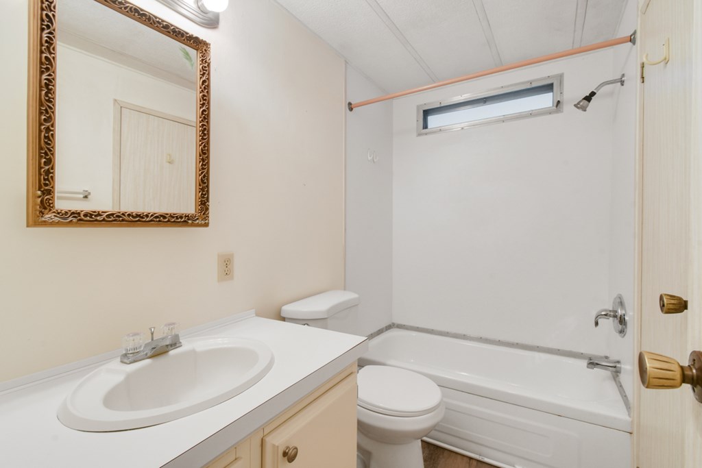 A bathroom with a white sink, toilet, and bathtub.