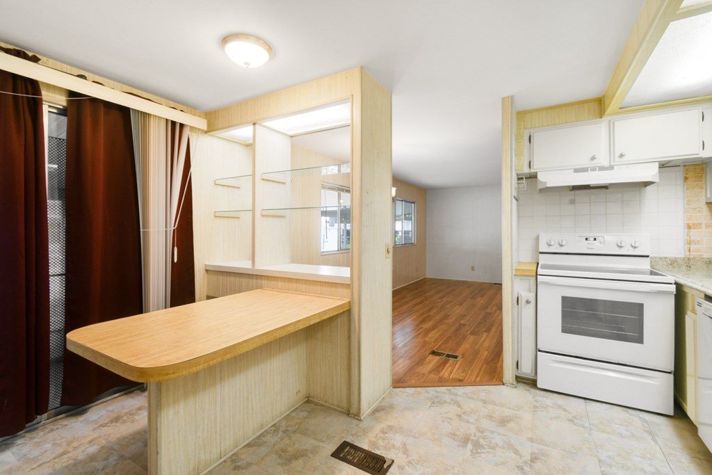A kitchen with a wooden counter and white appliances.