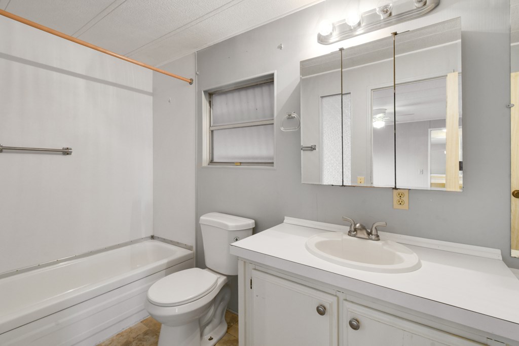 A white bathroom with a toilet, sink, and bathtub.