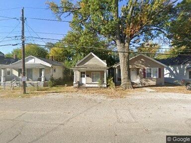 A row of houses with a tree in front of the first house.