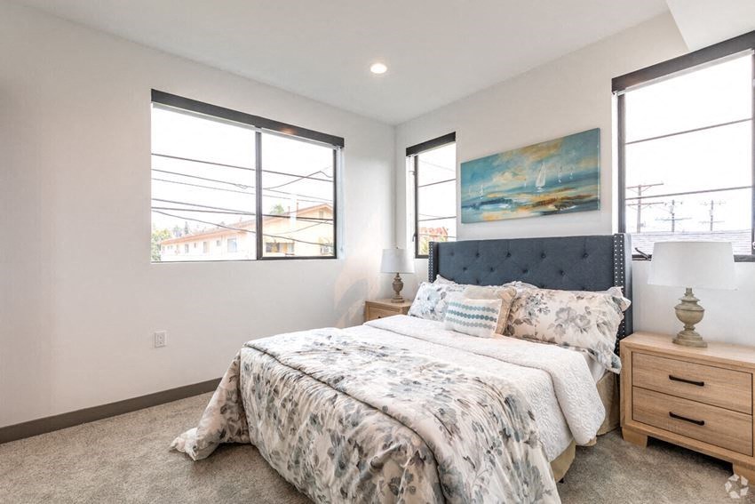 a bedroom with a bed and three windows