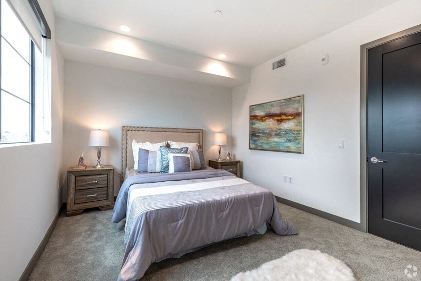 a bedroom with a bed and a black door