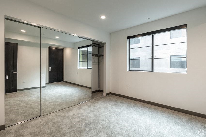 an empty room with mirrors and a window