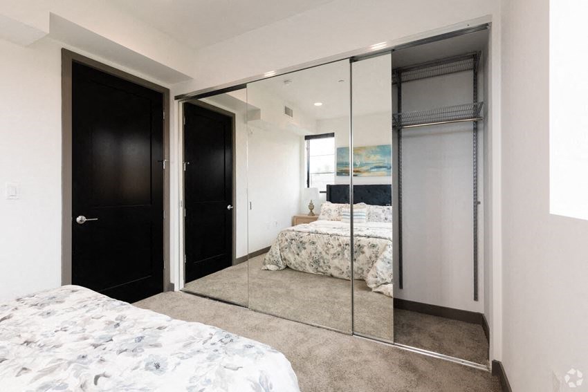 a bedroom with a large mirror and a bed