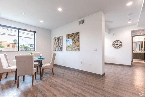 a dining room with a table and chairs and a clock on the wall