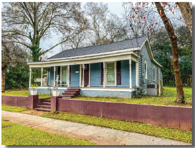 a blue house with blue shutters and a sidewalk