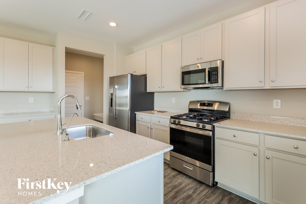 A kitchen with a sink, stove, and refrigerator.