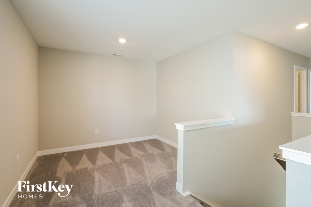 A room with a carpeted floor and a white wall.