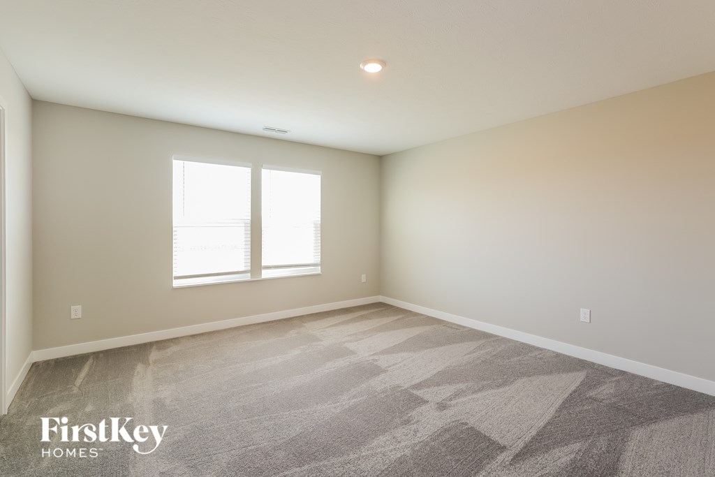 A room with a carpeted floor and a window.