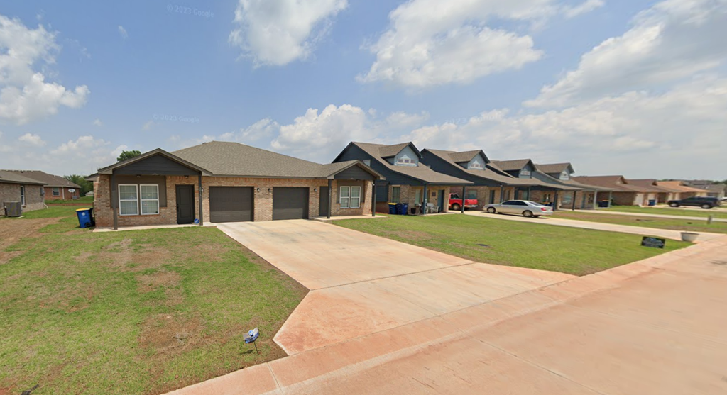 a home in a subdivision with a driveway and lawn