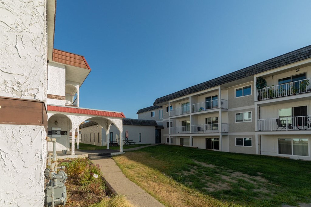 a view of a courtyard between two apartment buildings