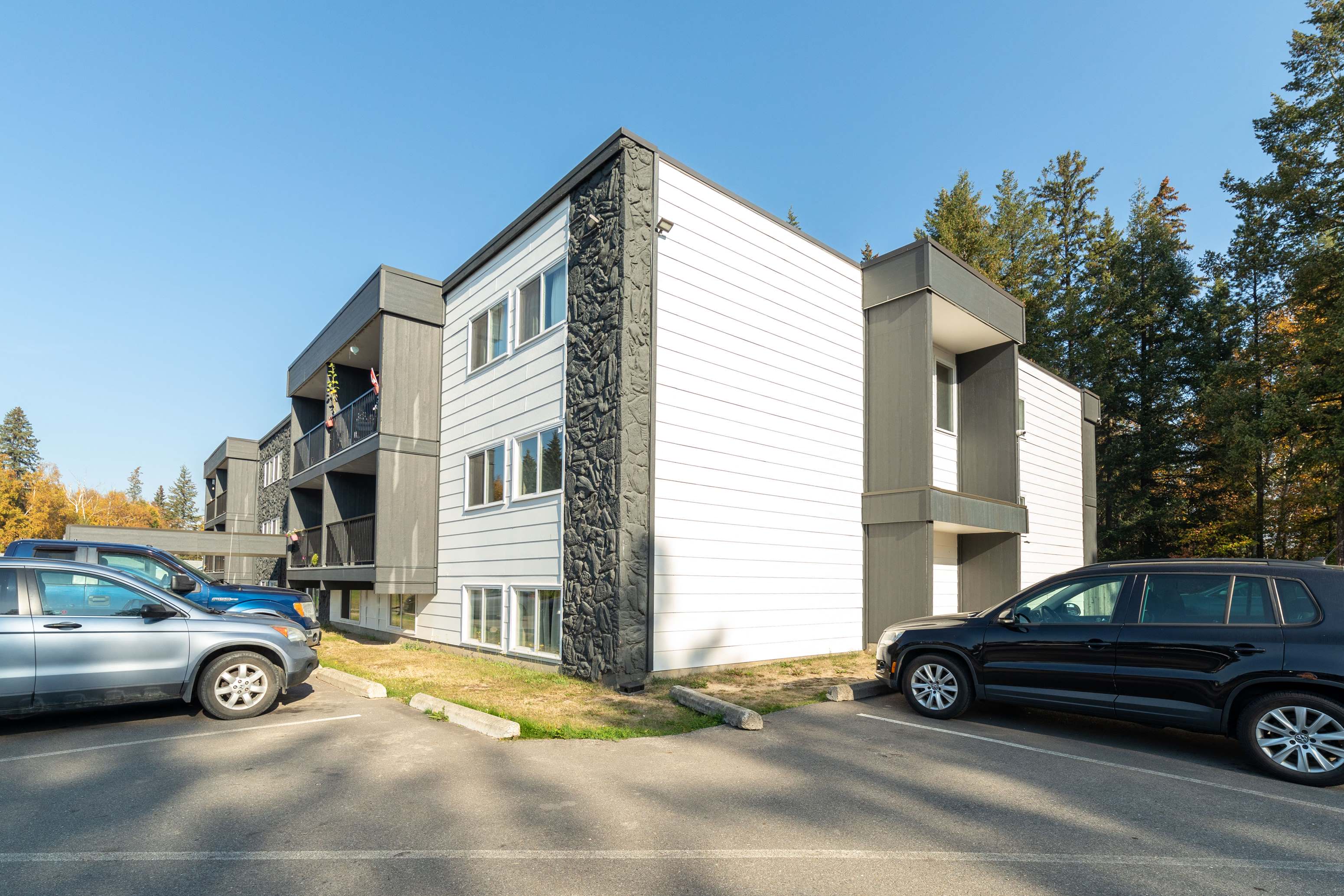 a view of a building with cars parked in front of it