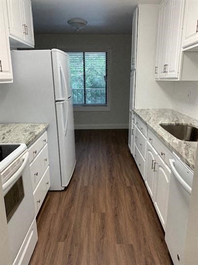 a white kitchen with a sink and a refrigerator