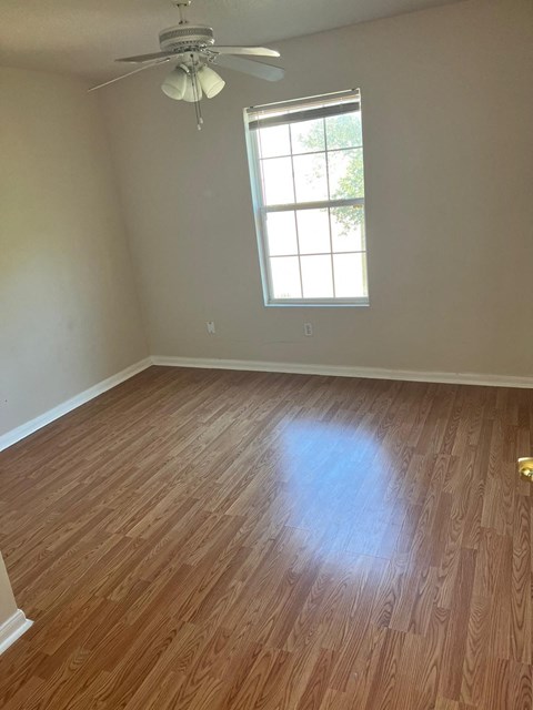 an empty room with wooden floors and a window